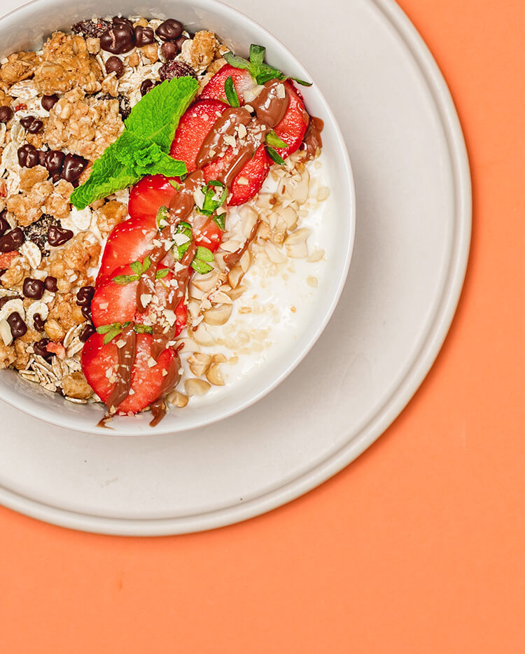 article4b-muesli-strawberry-jelly-peanut-granola.jpg Granola mit Milch, frischen Erdbeerscheiben und gruener Minze
